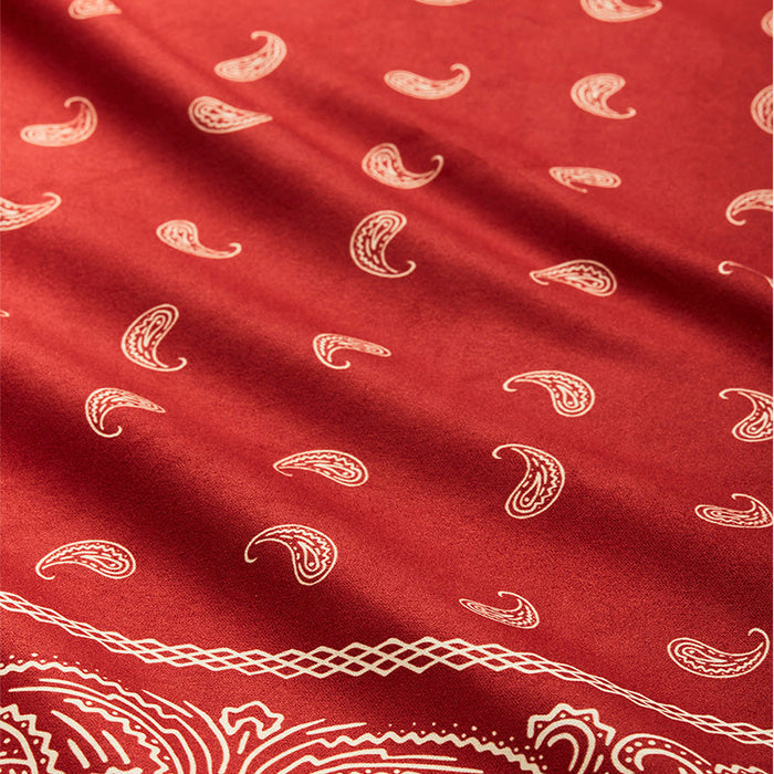 Nomadix Bandana Towel in deep red with white paisley and geometric designs, close-up view of soft fabric texture.