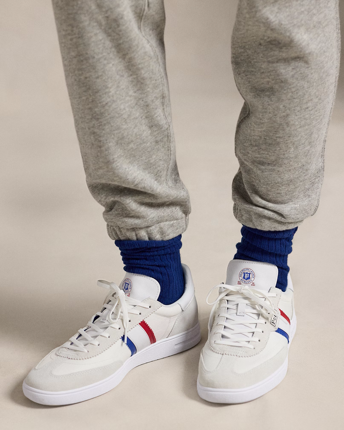Polo Ralph Lauren Bedford Suede-Paneled Sneaker in white with red and blue side stripes, suede accents, and logo detailing, lifestyle view.