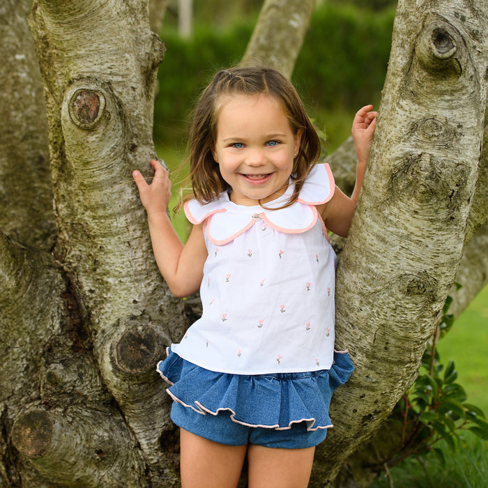 Young girl standing next to a tree in a park