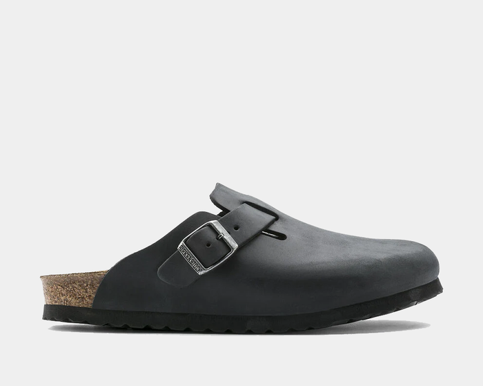 Birkenstock Boston Oiled Leather clogs in black with adjustable buckle and cork footbed, side view.
