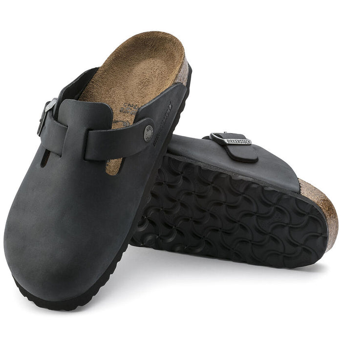 Birkenstock Boston Oiled Leather clogs in black with adjustable strap, cork footbed, and textured outsole, angled view.