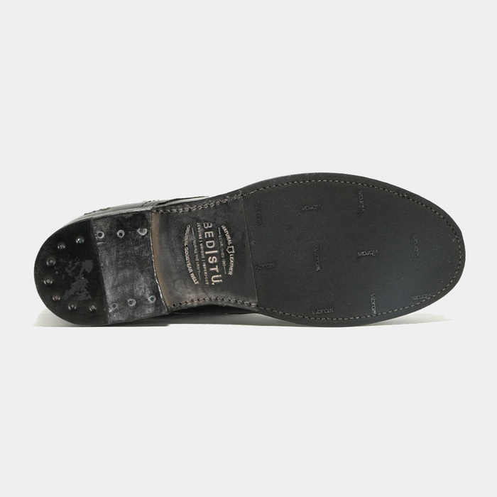 Bed Stu Bradley shoe sole in black with Vibram rubber grip, nail details on the heel, and Bed Stu branding, bottom view.