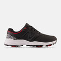 New Balance Golf Brighton Golf shoes in black with red accents, camouflage heel detail, and white outsole with red spikes, side view