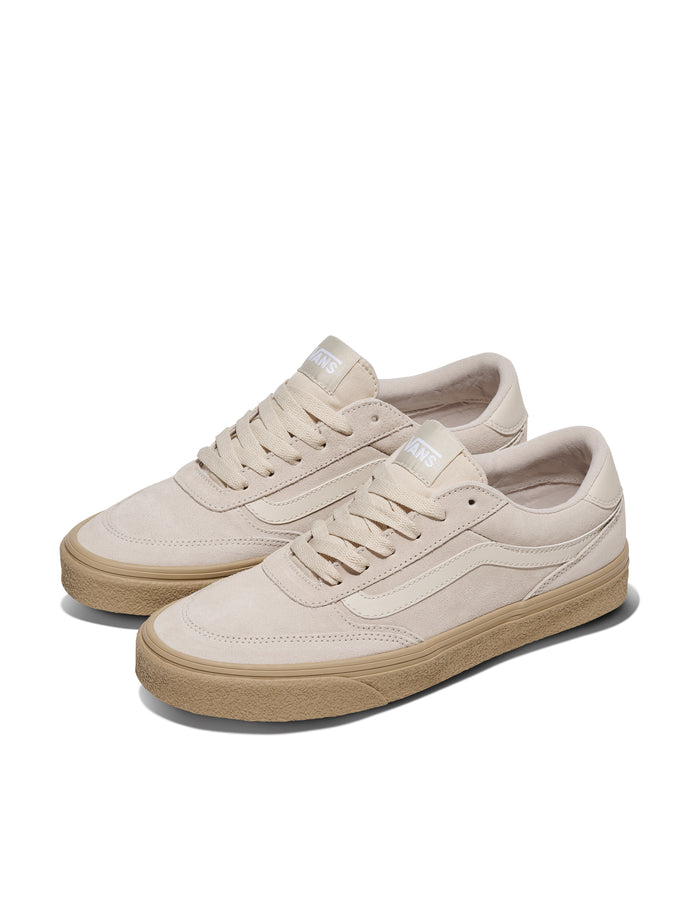 Vans Brooklyn sneakers in beige suede with gum rubber outsole, front angle showing lace-up closure and side stripe detailing.