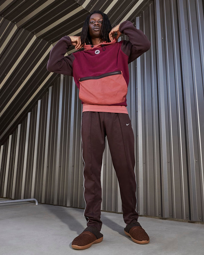 Nike Burrow SE slippers in dark brown with textured upper and cushioned sole, worn with casual outfit.