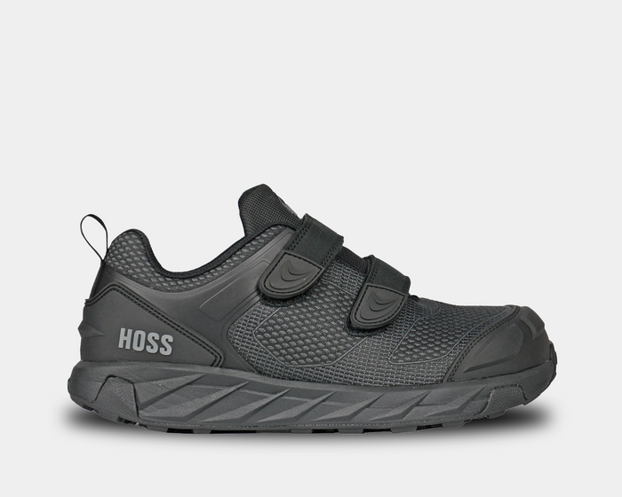 A black safety shoe with velcro closure, featuring a FlyKnit upper with molded toe cap and heel counter.