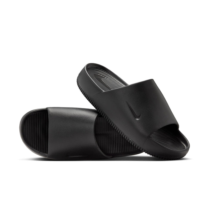 Nike Calm Slide sandals in black with textured footbed, minimalist design, and embossed logo, angled side view.