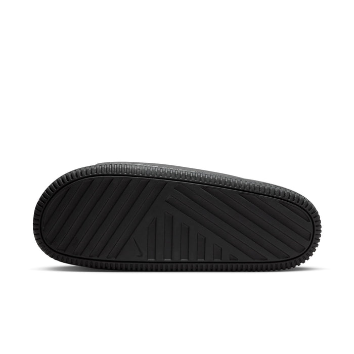 Nike Calm Slide sandals outsole in black with textured pattern and grooves for traction, bottom view.