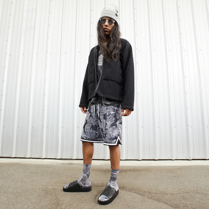Nike Calm Slide sandals in black with contoured footbed worn with socks, lifestyle context.
