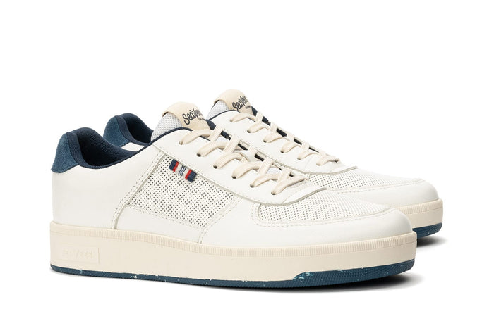 SeaVees Cardinal Sneaker in off-white with perforated leather upper, blue suede heel accent, and cream-colored sole, side angle view.