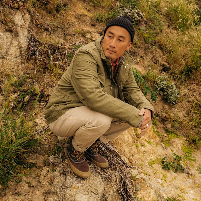 "SeaVees Cascade Range Boot in brown with tan sole and lace-up design, worn outdoors on a rocky terrain"