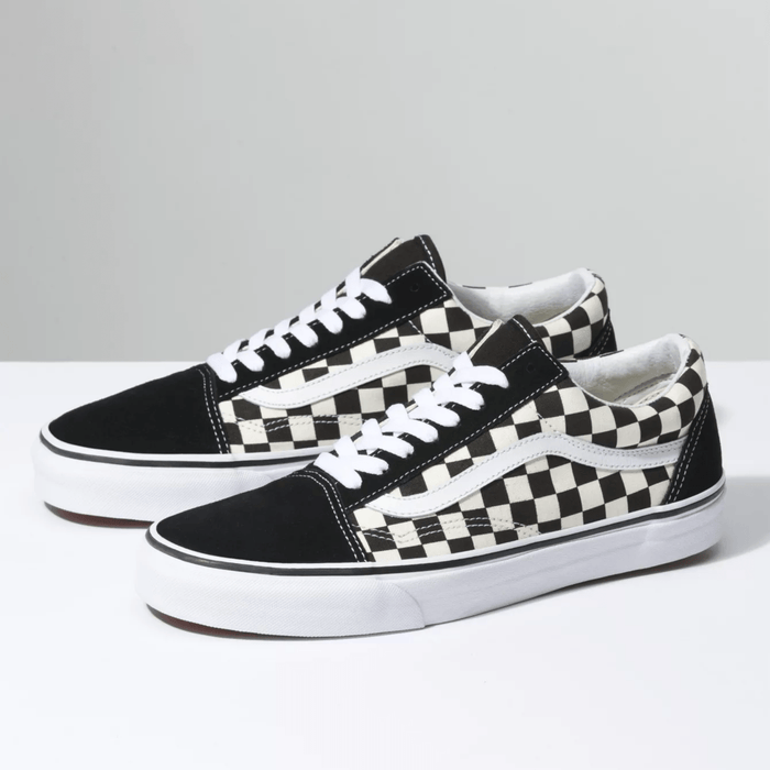 Vans Checkerboard Old Skool sneakers featuring black suede and black-and-white checkerboard canvas upper with white side stripe and laces, angled front-side view.