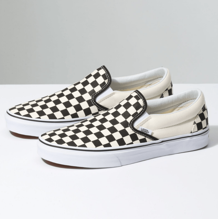 Vans Checkerboard Slip On shoes with black and white canvas upper, padded collar, and white rubber outsole, side angle view.