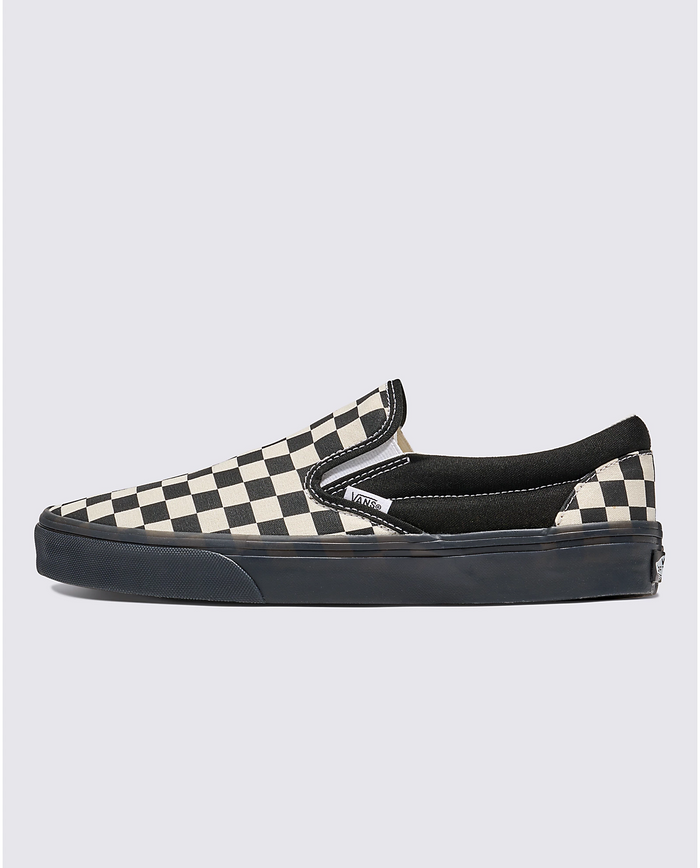 Vans Checkerboard Slip On shoes in black and white checkered canvas with black elastic side accents and black rubber sole, side view.
