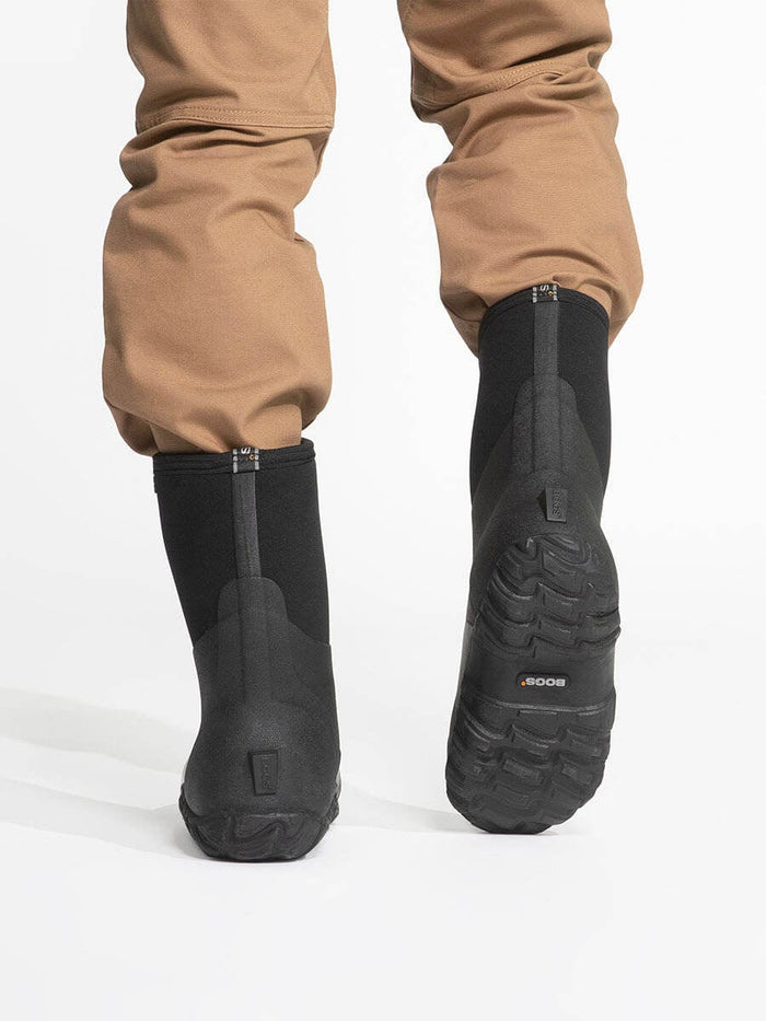 Bogs Classic Mid Boot black waterproof boots with textured rubber outsoles, back view showing tread pattern.