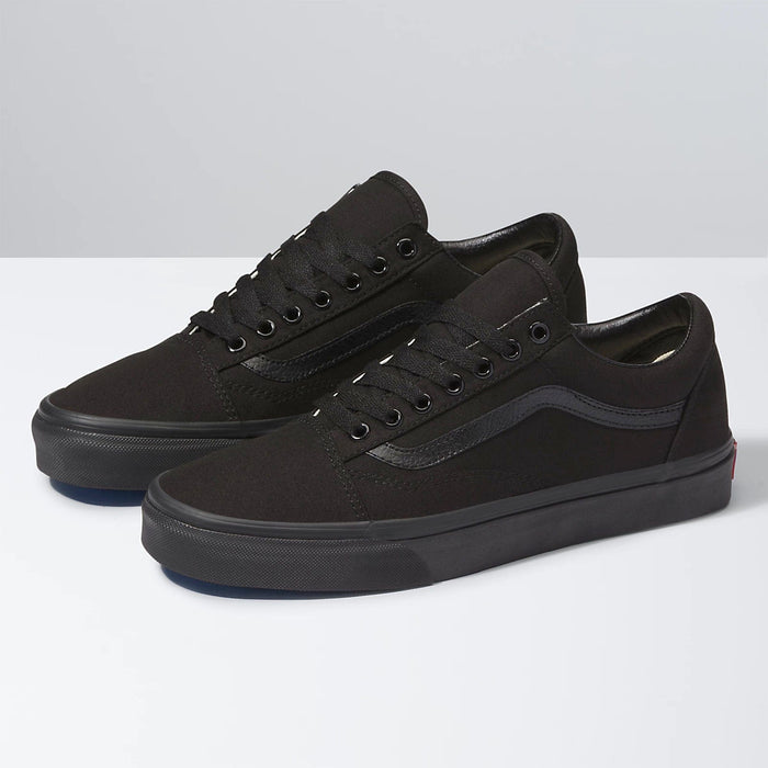 Vans Classic Old Skool sneakers in all-black featuring low-top design, canvas and suede upper, and signature sidestripe, angled view.