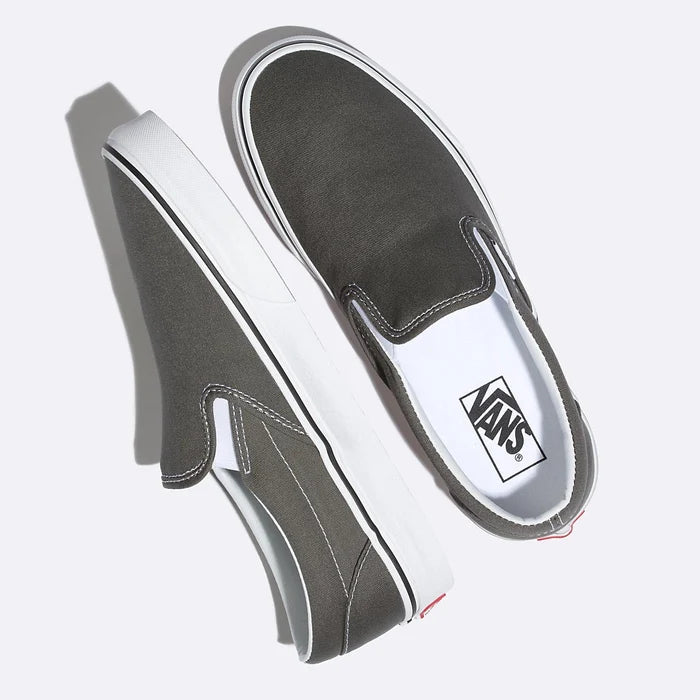 Vans Classic Slip On shoes in dark gray canvas with white stitching, padded collar, and white rubber midsole, top angled view.