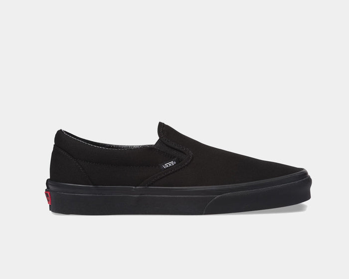 Vans Classic Slip On shoes in black canvas with elastic side accents and rubber sole, side view.