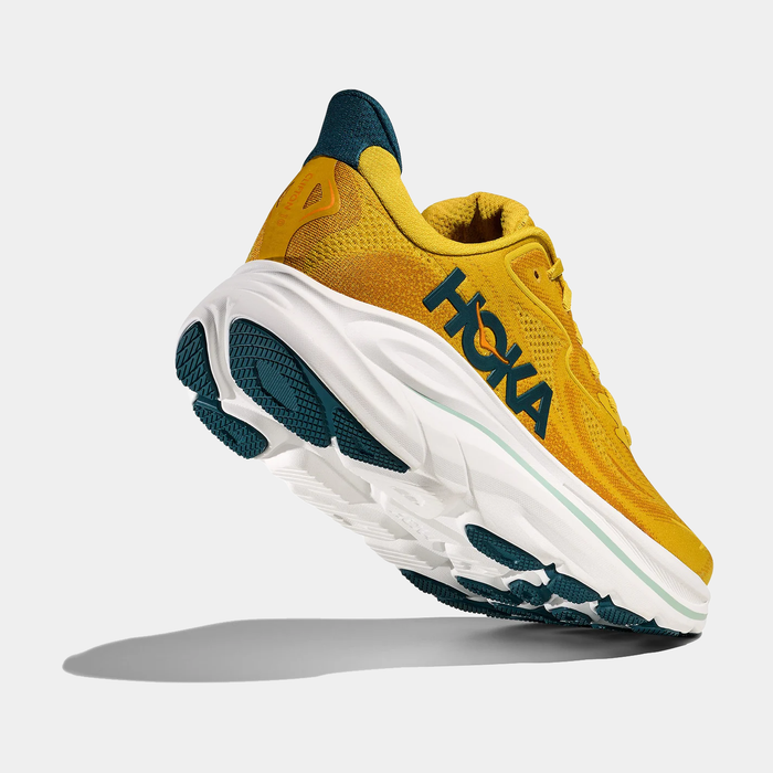 HOKA Clifton 10 running shoes in vibrant yellow with blue accents, breathable mesh upper, and white cushioned midsole, angled back view.