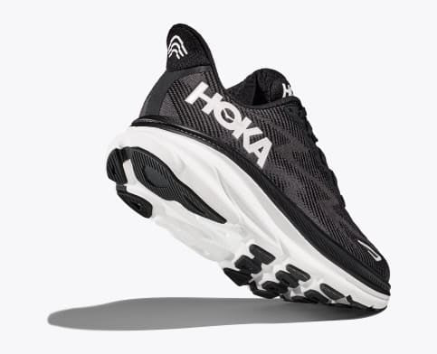 HOKA Clifton 9 running shoes in black with white logo, breathable mesh upper, and cushioned sole, angled back-side view showing outsole.