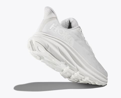 HOKA Clifton 9 running shoes in all-white with lightweight foam midsole and textured outsole, angled side and sole view.