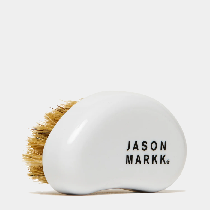 Jason Markk Complete Clean Kit cleaning brush with white ergonomic handle and natural bristle design, side view.