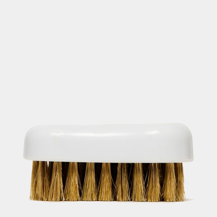 Jason Markk Complete Clean Kit shoe cleaning brush with white plastic handle and natural bristles, side view.