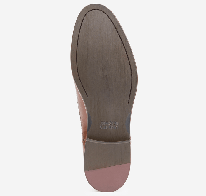 Johnston & Murphy Conard 2.0 Plain Toe shoe sole, featuring a smooth brown leather finish with embossed branding and a pink heel.