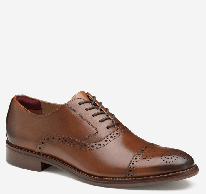 Johnston & Murphy Conard Cap Toe dress shoe in brown leather with brogue detailing and cap-toe design, side view.