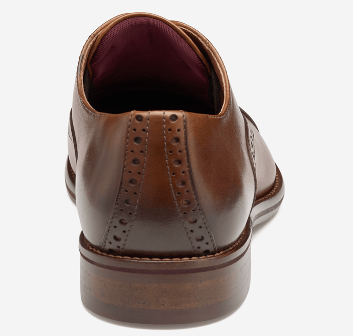 Johnston & Murphy Conard Cap Toe dress shoes in brown leather with broguing details, back view showcasing stacked heel.