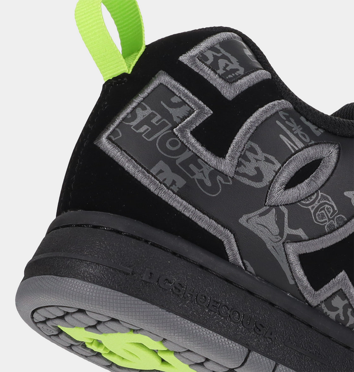 "DC Footwear Court Graffik shoes in black with bold gray logo detailing, graffiti-inspired graphics, and neon green pull tab, side and heel view"