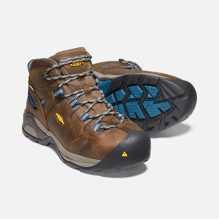 Keen Detroit XT Steel Toe Mid Waterproof Boots in brown leather with blue accents, steel toe protection, and rugged outsole, angled front and sole view.