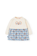 Children's outfit with cream top and blue checkered skirt on a white background