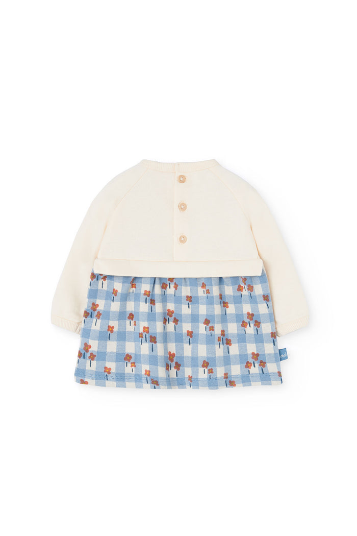 White cardigan with a blue checkered skirt on a white background