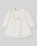White baby dress with lace details on a gray background