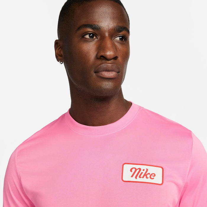 Nike Dri-FIT Fitness T-Shirt in bright pink with white chest graphic and red Nike branding, front view.