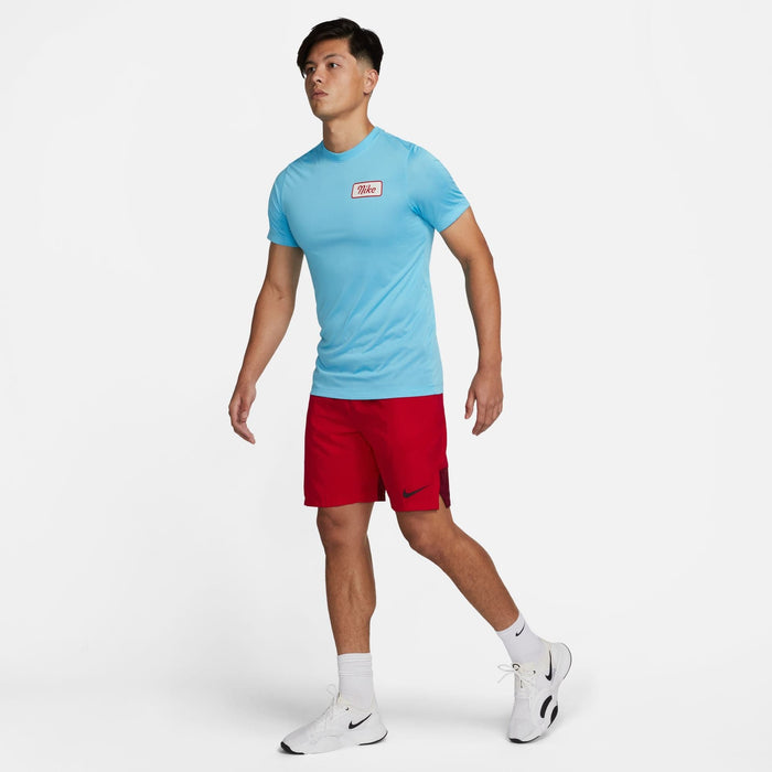 Nike Dri-FIT Fitness T-Shirt in light blue with a red and white Nike logo on the chest, worn during fitness activity.
