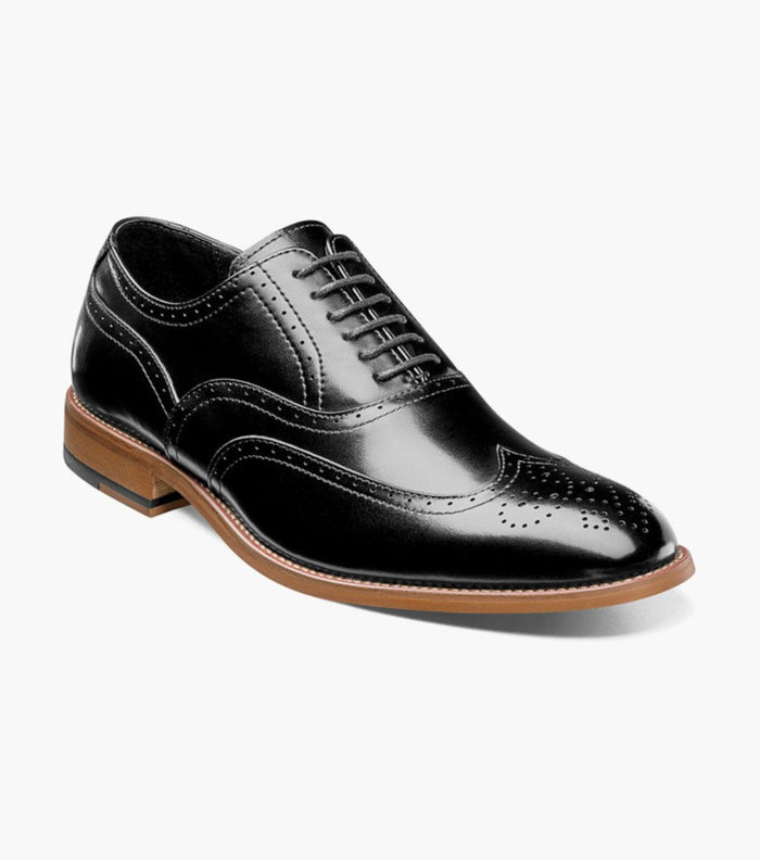 Stacy Adams Dunbar Wingtip Oxford dress shoes in black leather with brogue detailing and tan sole, angled side view.