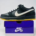 Nike Dunk Low Pro SB sneaker in black, white, and gum colors on a purple Nike SB shoebox, 2025 model