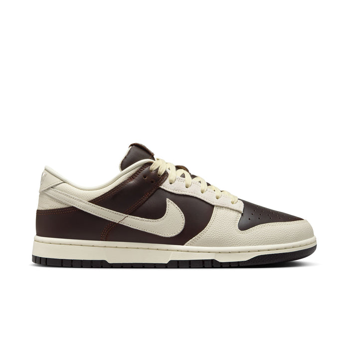Nike Dunk Low sneakers in brown and cream leather with perforated toe box, side view showing signature Swoosh and padded collar