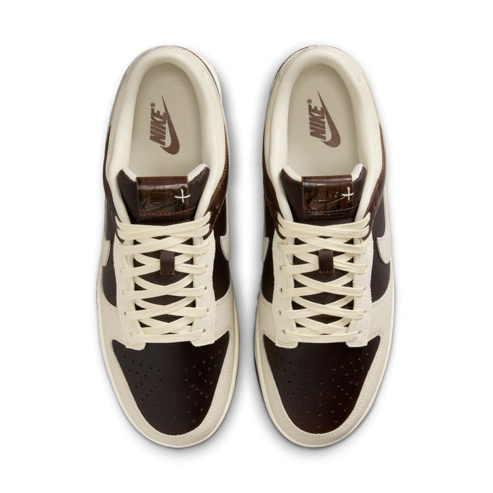 Nike Dunk Low sneakers top view in cream and dark brown with perforated toe box, leather overlays, and branded insoles.