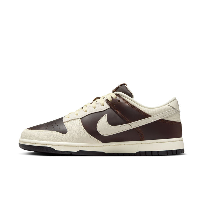 Nike Dunk Low sneakers in brown and cream leather with a textured upper and signature Swoosh logo, side view.