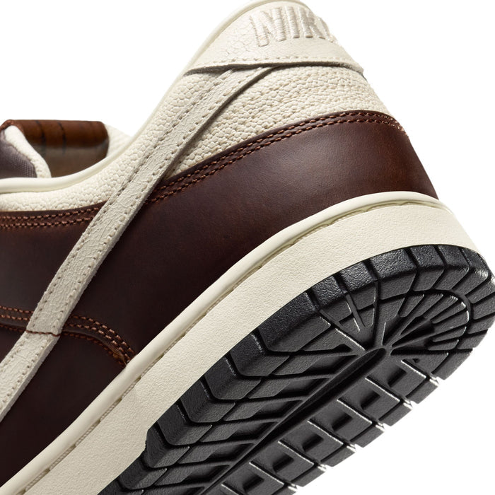 Nike Dunk Low sneakers with brown leather upper and textured cream overlays, black rubber outsole, and heel detail.