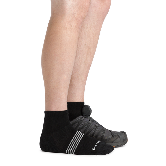 Darn Tough Element Quarter Lightweight Running Sock in black with white stripe detail and logo, worn with running shoes, side view.