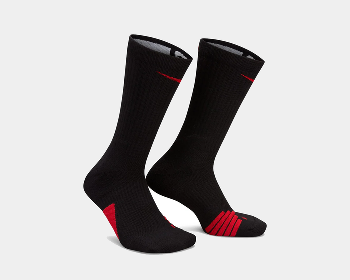 Nike Elite Crew socks in black with red accents, ribbed construction, and cushioned zones, angled view.