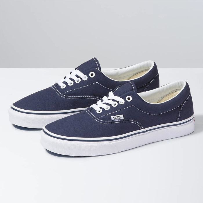 Vans Era Core sneakers in navy blue canvas with white stitching, white laces, and rubber outsole, angled front-side view.