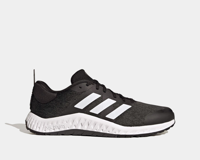 Adidas Everyset Trainer shoes in black with white accents, featuring mesh upper, cushioned midsole, and dual-density outsole, side view.
