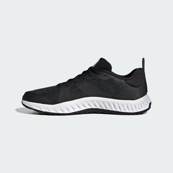 Adidas Everyset Trainer shoes, side view in black with a mesh upper and white cushioned sole featuring textured pattern.