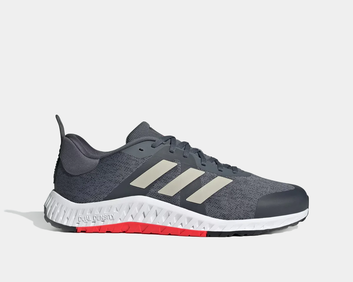 Adidas Everyset Trainer shoes in gray with a breathable mesh upper, light beige three-stripe design, and white sole with red accents, side view.