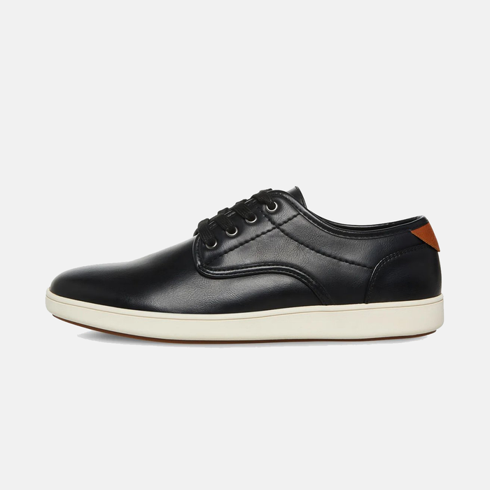 Steve Madden Fenta Leather shoes in black leather with tan heel accent and white rubber sole, side view.